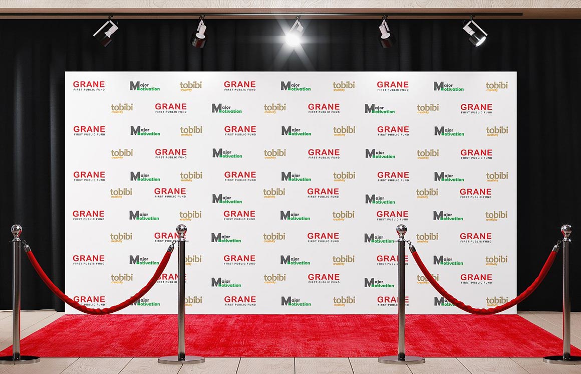 A movie theater lobby with stanchions and a small step-and-repeat backdrop as attendees queue for check-in