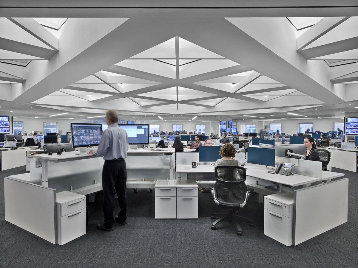 A newsroom work area with notes, a laptop, and marked-up printouts, suggesting careful fact-checking and verification