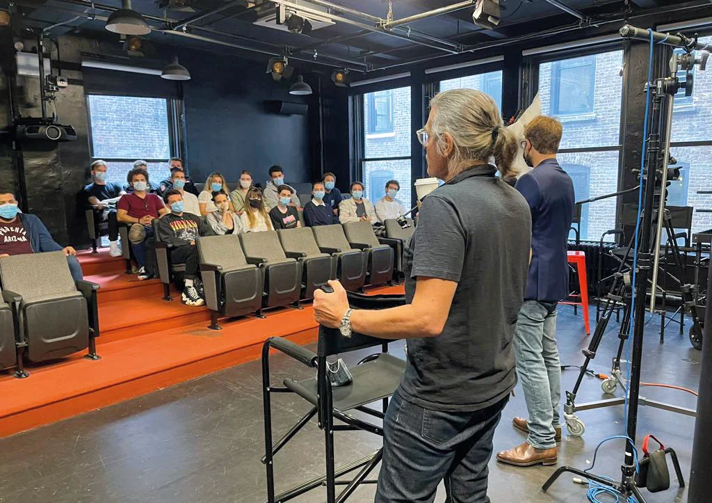 A theatre audition holding room with actors seated quietly holding sheet music and headshots while waiting to be called in