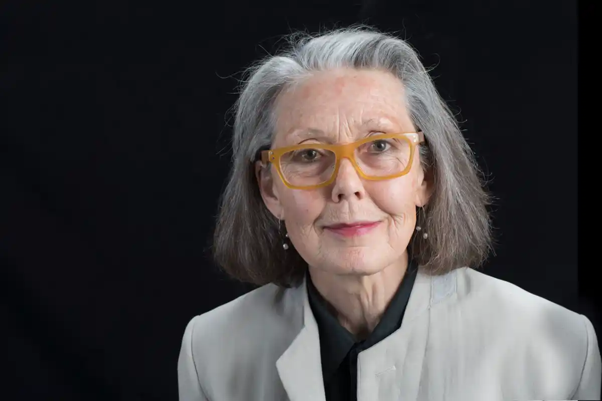 Anne Carson at a literary event, captured in a candid moment as she looks slightly off camera