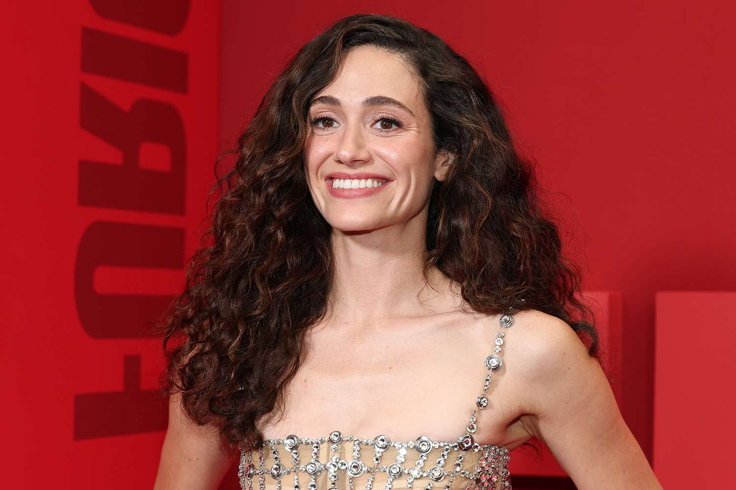 Emmy Rossum posing for a portrait, looking calmly toward the camera in a studio setting