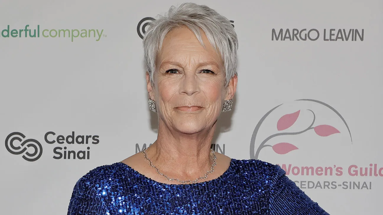 Jamie Lee Curtis arriving at a formal evening gala in Beverly Hills, dressed in elegant attire, photographed on a red carpet with event lighting