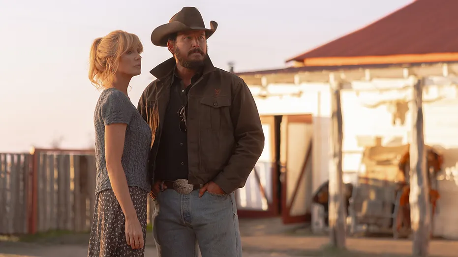 Kelly Reilly and Cole Hauser together in a dramatic scene from Dutton Ranch, standing outdoors in daylight with serious expressions