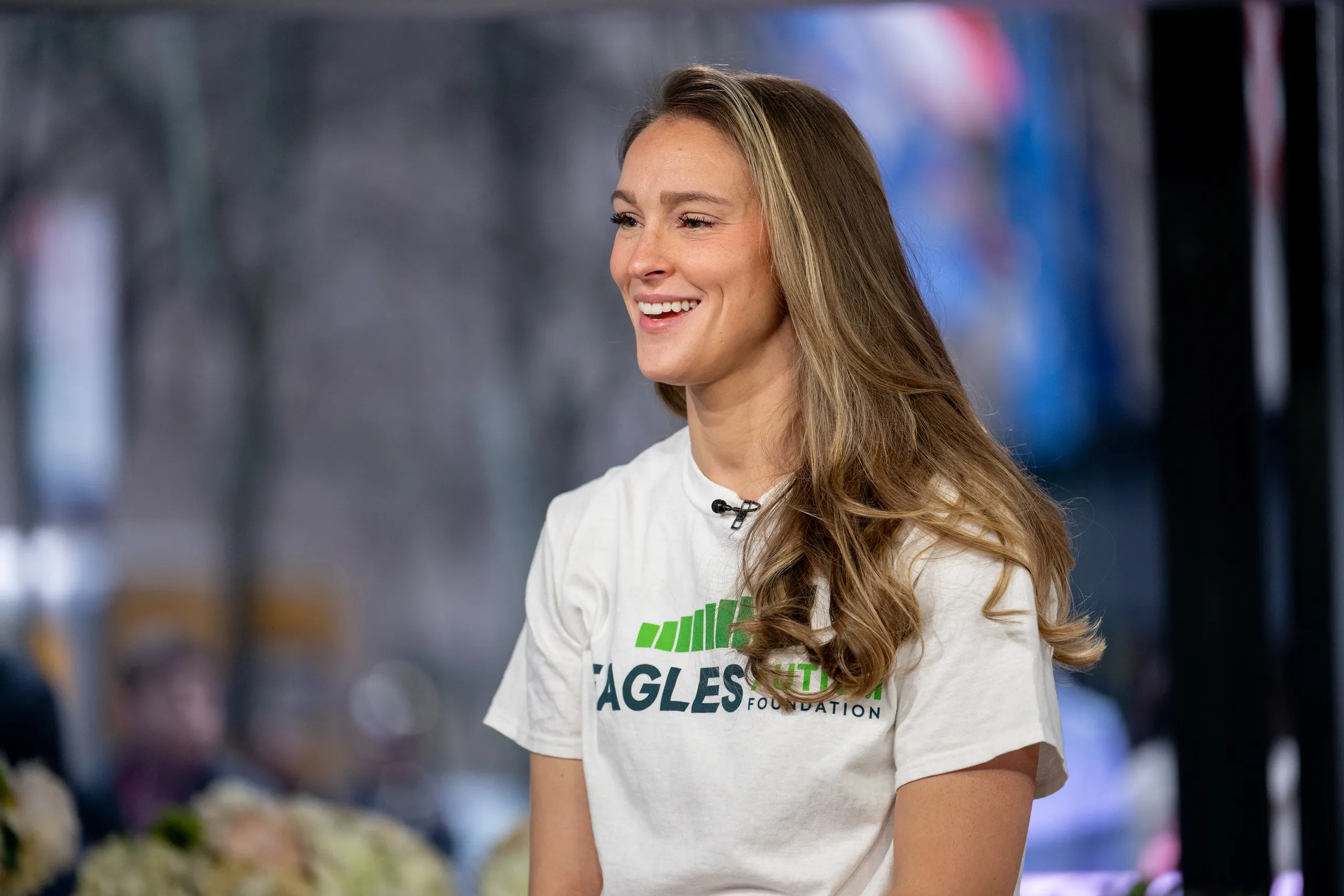 Kylie Kelce smiling at a public appearance, facing photographers.