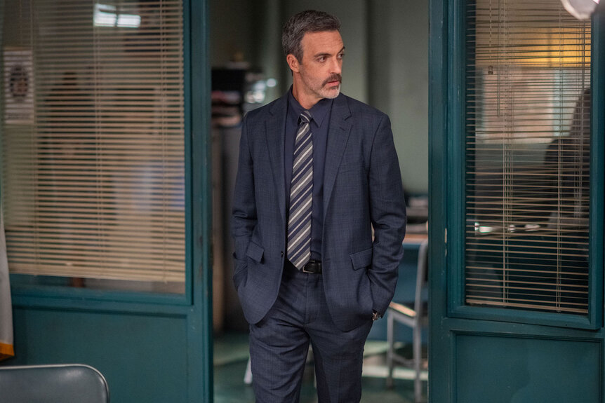 Reid Scott at a Law & Order promotional appearance, standing in front of a step-and-repeat backdrop.