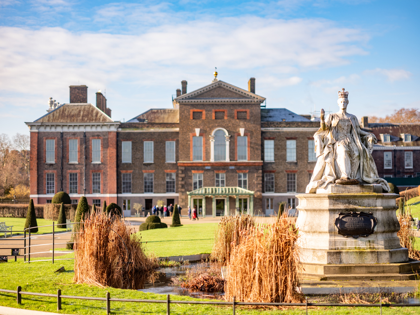 The front gates and facade of Kensington Palace in London, with visitors nearby